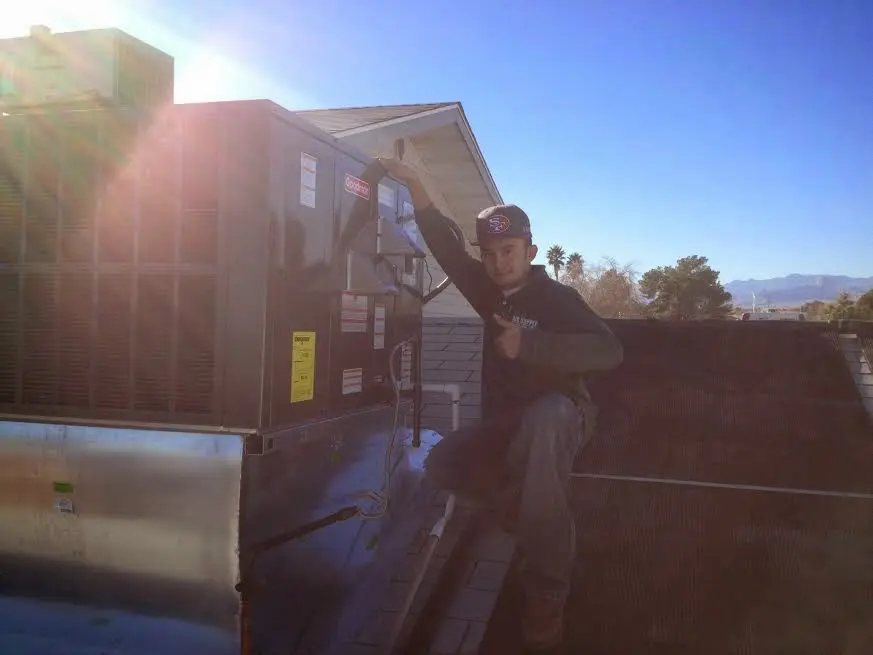 HVAC technician performing AC Tune-Up on a rooftop unit in Fish Hawk
